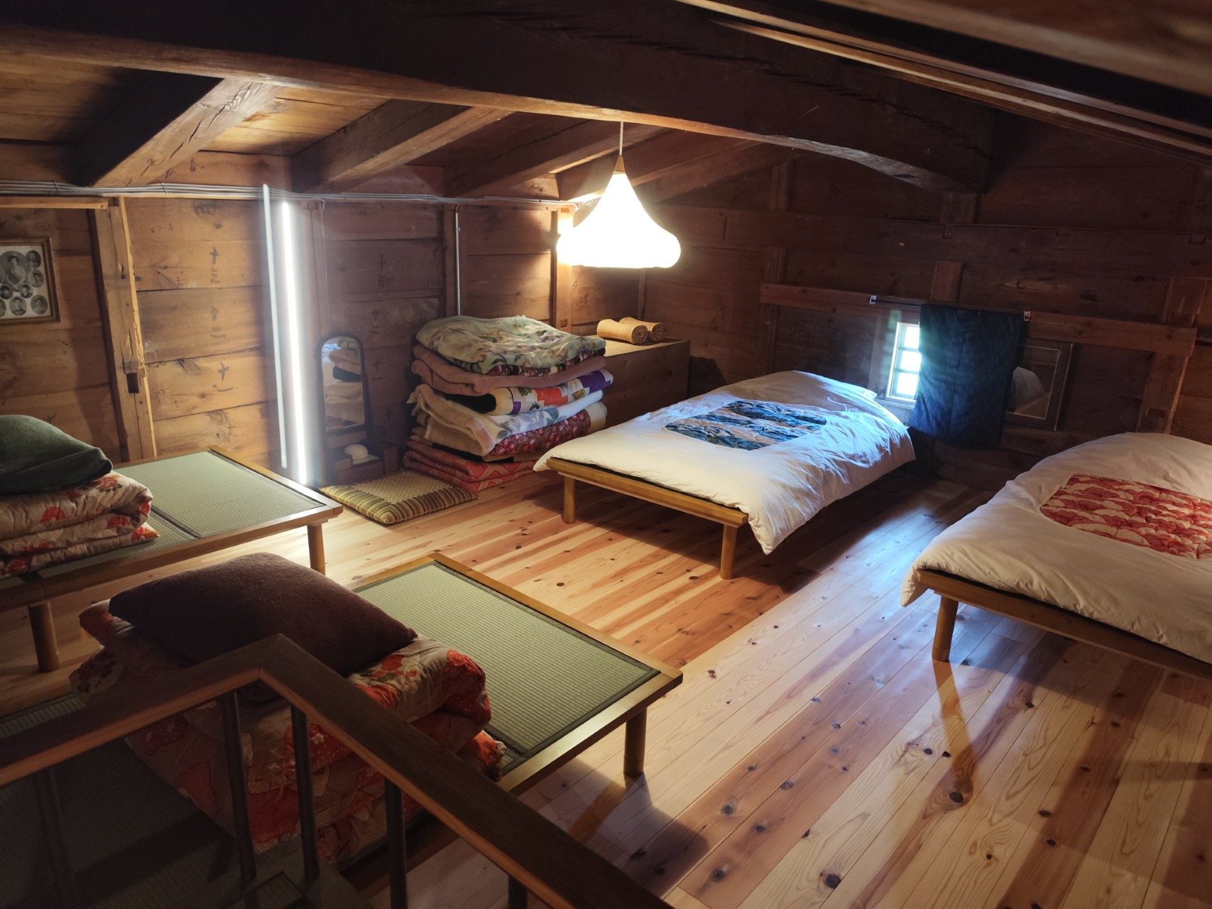Upstairs sleeping loft with four beds under cedar rafters